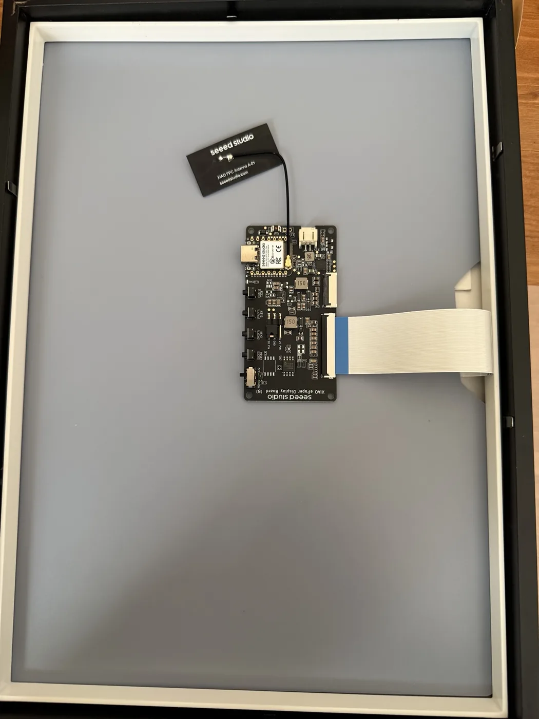 額縁の背面に粘土板を入れ、EE04とアンテナを仮置きした製作途中の写真